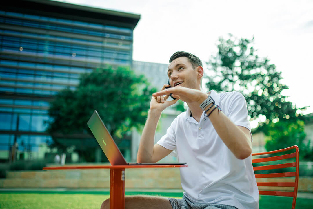 man answering a sales call outdoors