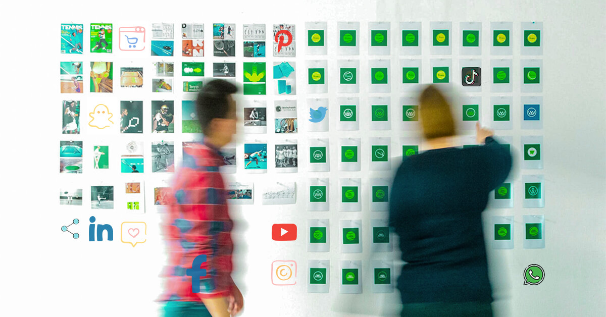 two office workers putting up Polaroid-like photos on the wall