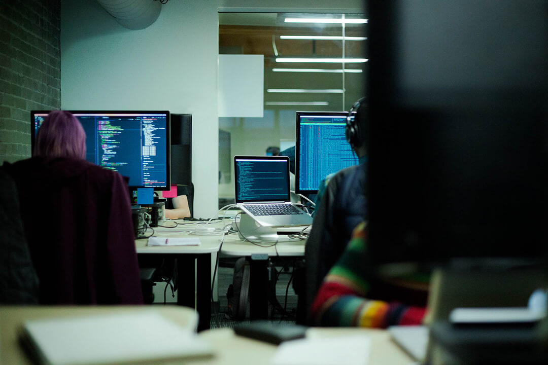 interior view of an office with employees busy working on software codes