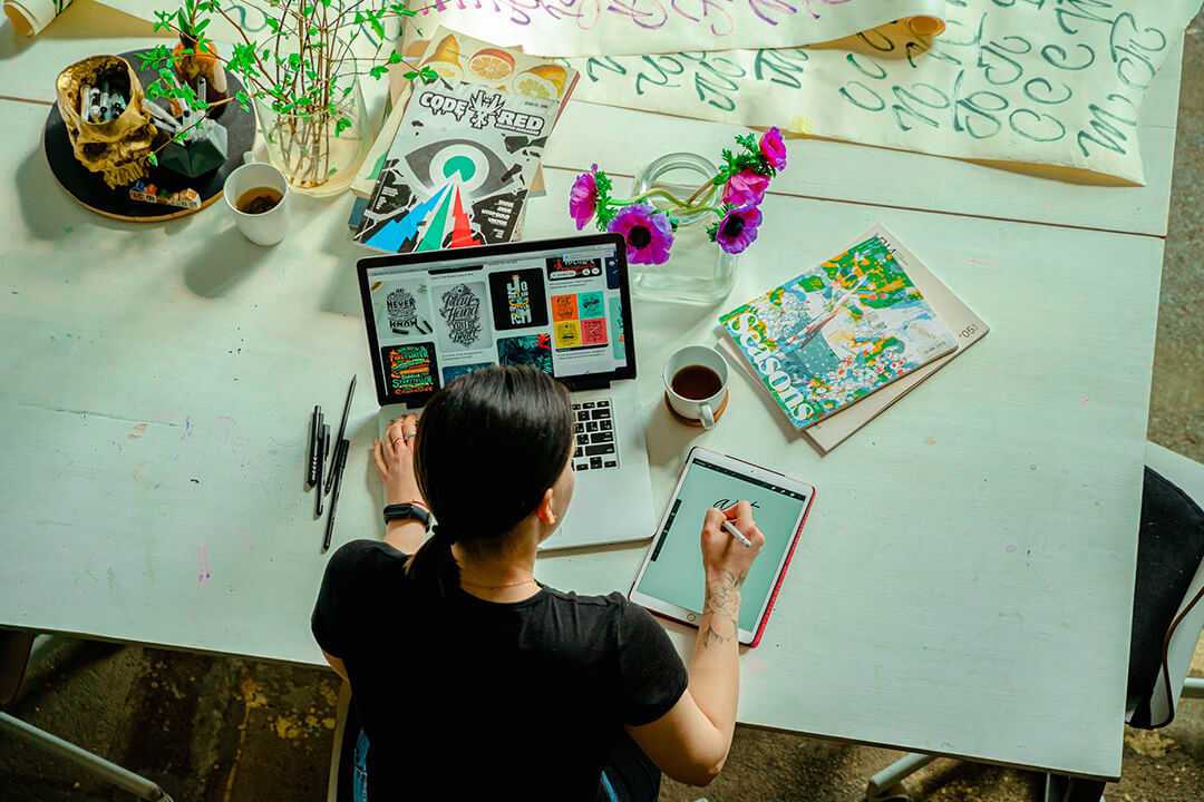 woman on laptop, updating social media posts