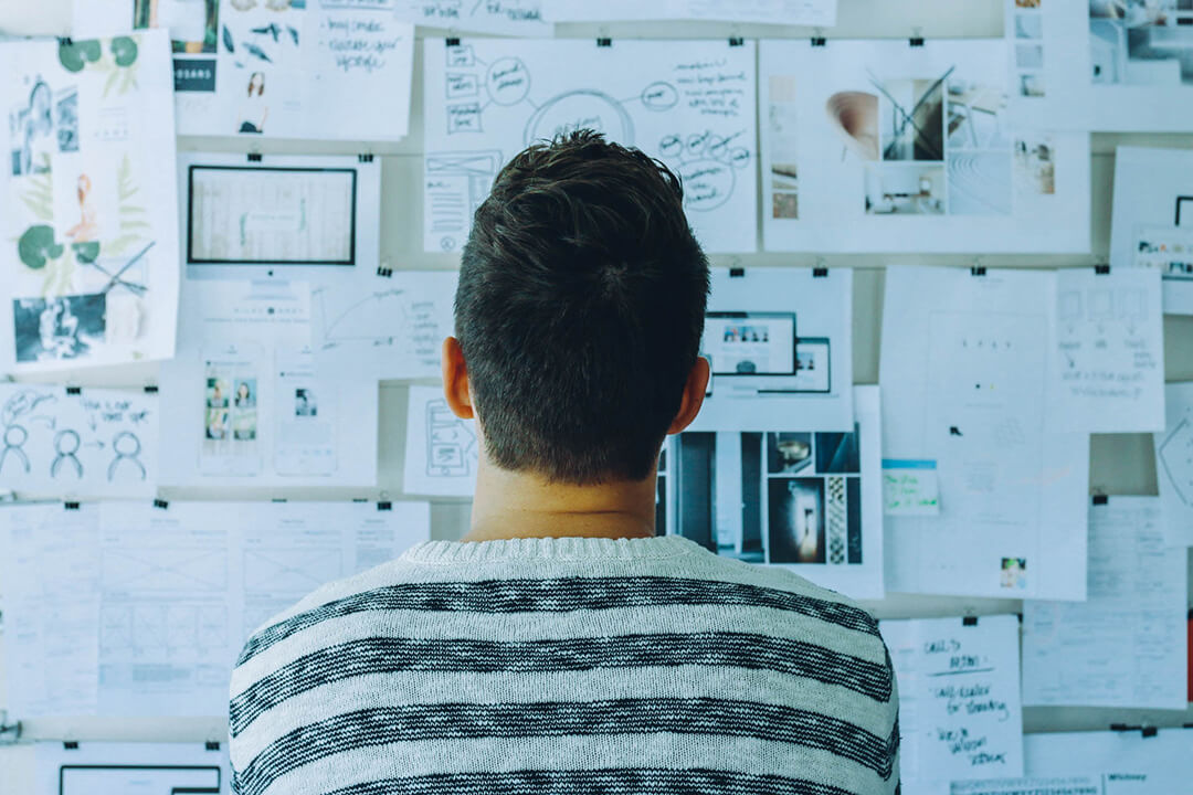 office worker studying the details of notes posted on a board